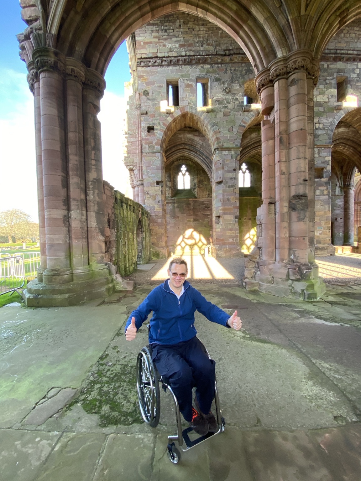Paul in a wheelchair inside the historic building, showing a real visit in progress